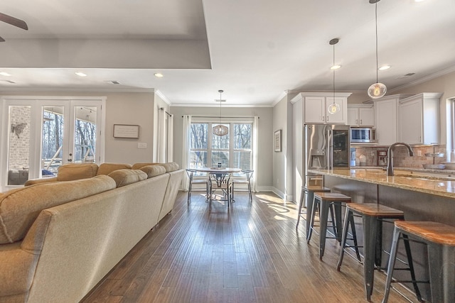 living room with ornamental molding, sink, dark hardwood / wood-style floors, and french doors