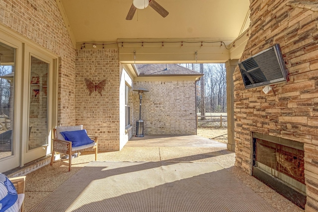 view of patio / terrace featuring ceiling fan and an outdoor stone fireplace