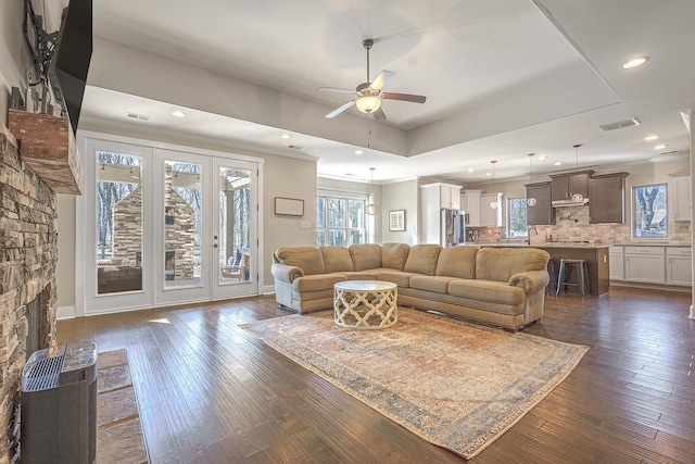 living room featuring sink, crown molding, ceiling fan, a fireplace, and dark hardwood / wood-style flooring