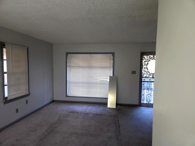 carpeted empty room with a textured ceiling