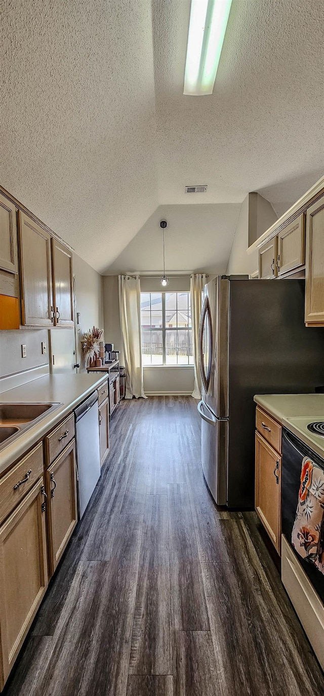 kitchen with lofted ceiling, stainless steel appliances, dark hardwood / wood-style floors, a textured ceiling, and decorative light fixtures