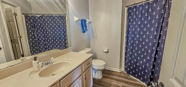 bathroom with vanity, toilet, curtained shower, and hardwood / wood-style floors