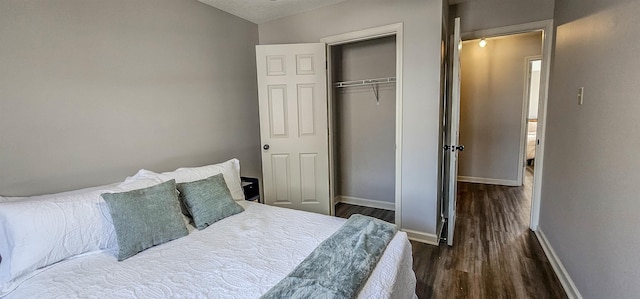 bedroom with dark hardwood / wood-style flooring and a closet