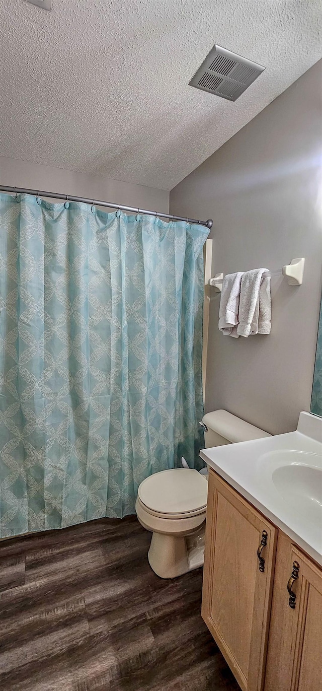 bathroom with vanity, hardwood / wood-style floors, a textured ceiling, and toilet