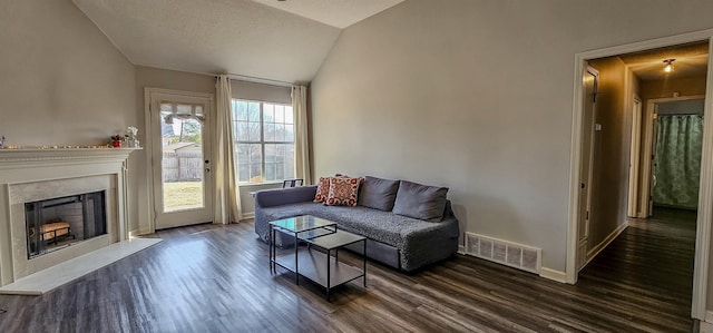 living room with dark hardwood / wood-style floors, vaulted ceiling, and a textured ceiling