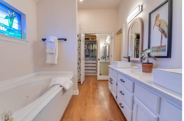 bathroom with vanity, hardwood / wood-style flooring, and a bathing tub