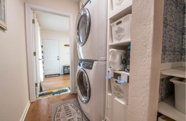 washroom featuring stacked washer and dryer and wood-type flooring