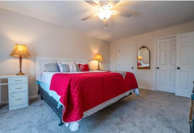 carpeted bedroom featuring ceiling fan and two closets