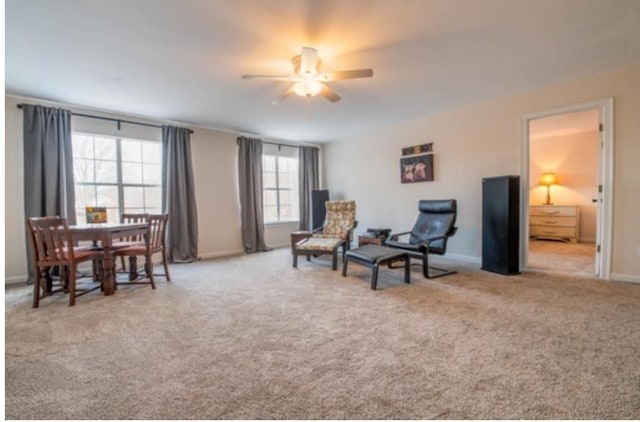 living area with ceiling fan and light colored carpet