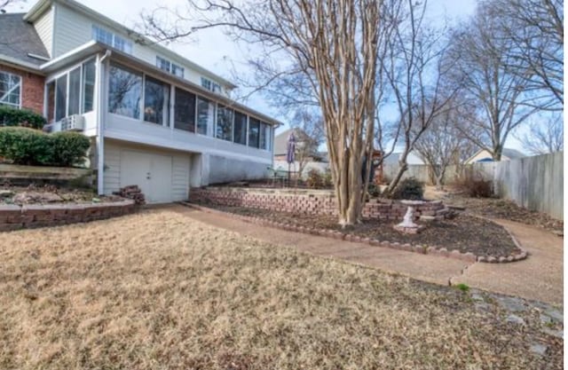 view of property exterior with a yard and a sunroom