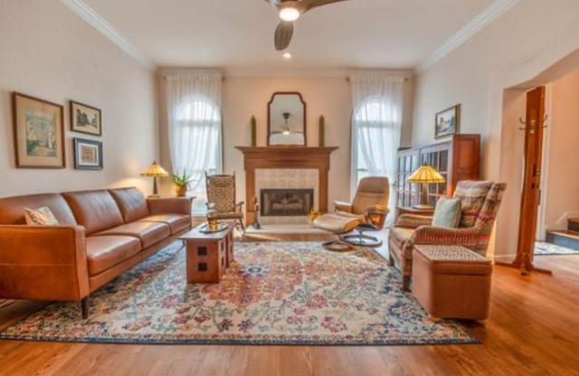 sitting room featuring hardwood / wood-style flooring, crown molding, and a healthy amount of sunlight