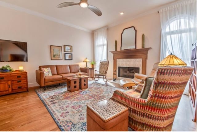 living room with crown molding, ceiling fan, and light hardwood / wood-style floors