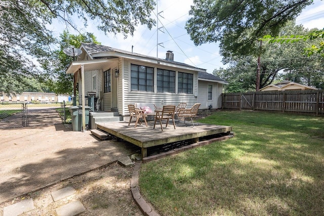 back of house featuring a wooden deck and a yard