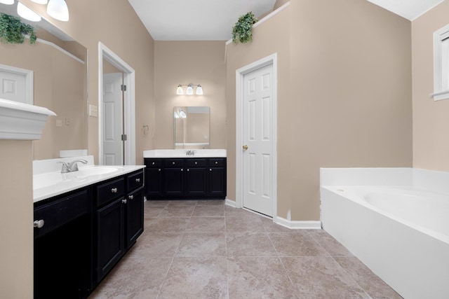 bathroom featuring vanity, a bath, and tile patterned flooring