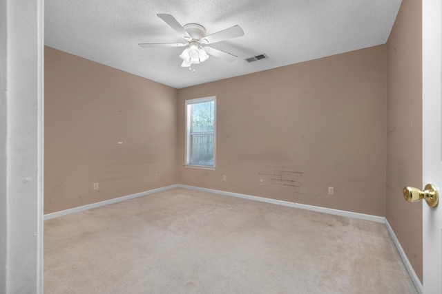 carpeted spare room with a textured ceiling and ceiling fan