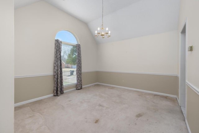 empty room featuring lofted ceiling, light colored carpet, and a chandelier