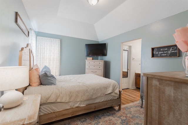 bedroom with wood-type flooring and vaulted ceiling