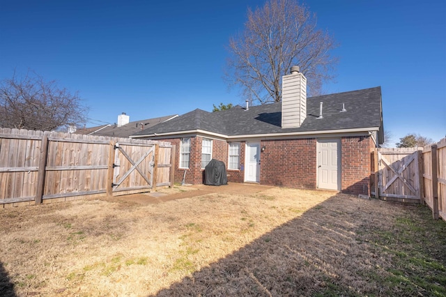 back of house with a lawn