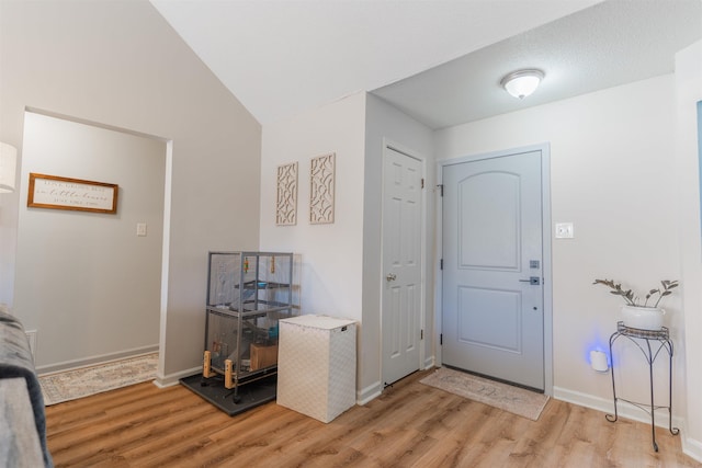 entrance foyer with lofted ceiling and light hardwood / wood-style flooring