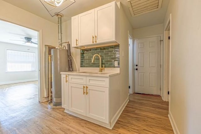 hall featuring water heater, sink, and light hardwood / wood-style flooring