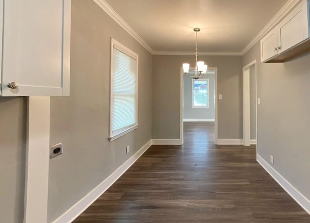 unfurnished dining area featuring an inviting chandelier, ornamental molding, and dark hardwood / wood-style flooring