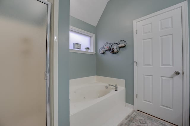 bathroom featuring lofted ceiling and plus walk in shower