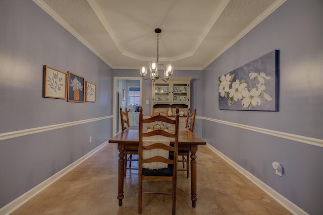 dining area featuring crown molding, a raised ceiling, and a notable chandelier