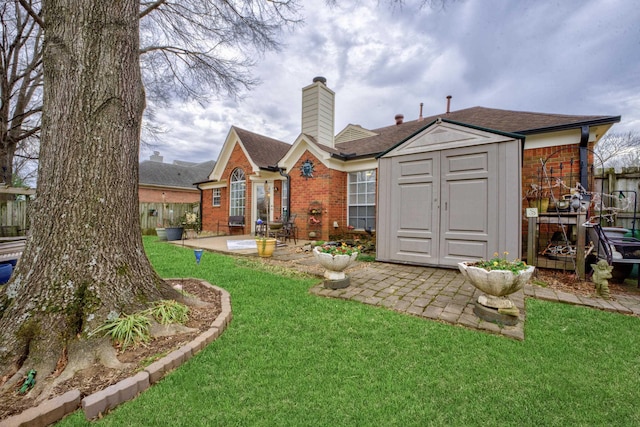 rear view of property featuring a storage unit, a patio area, and a lawn