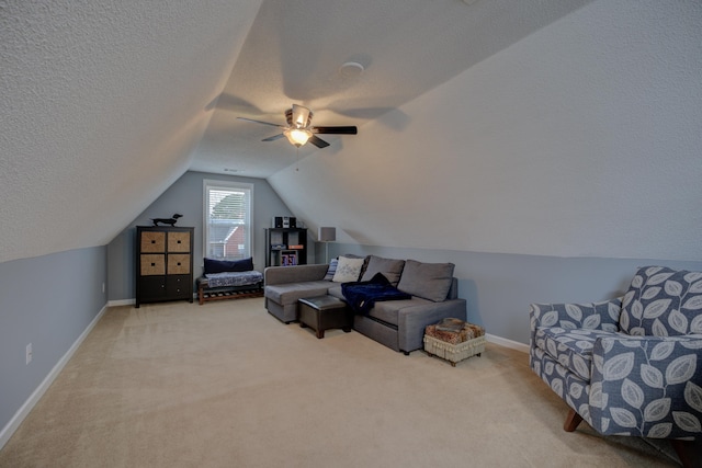 interior space featuring ceiling fan, lofted ceiling, carpet flooring, and a textured ceiling