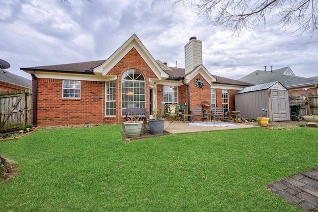 back of house featuring a storage shed, a yard, and a patio