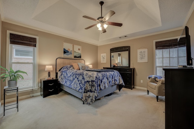 bedroom featuring ceiling fan, ornamental molding, a textured ceiling, light colored carpet, and a raised ceiling