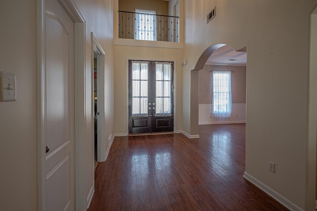 entrance foyer with a towering ceiling and dark hardwood / wood-style floors