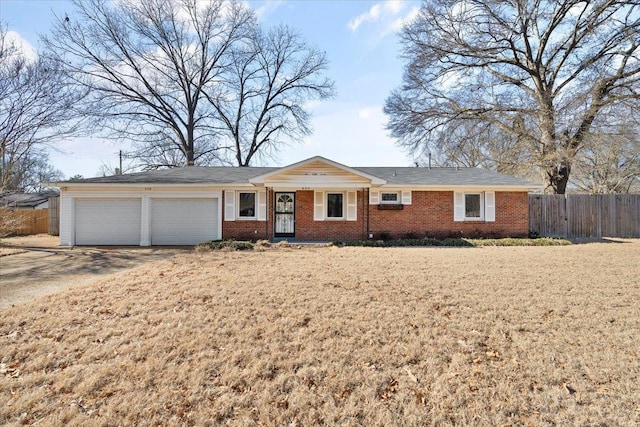 ranch-style home featuring a garage, concrete driveway, brick siding, and fence