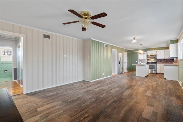 unfurnished living room with dark wood-style floors, visible vents, and crown molding