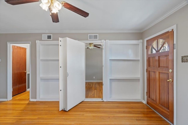 entrance foyer with light wood-type flooring, baseboards, visible vents, and crown molding