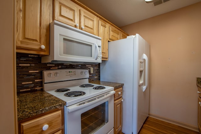 kitchen with light brown cabinets, backsplash, and white appliances