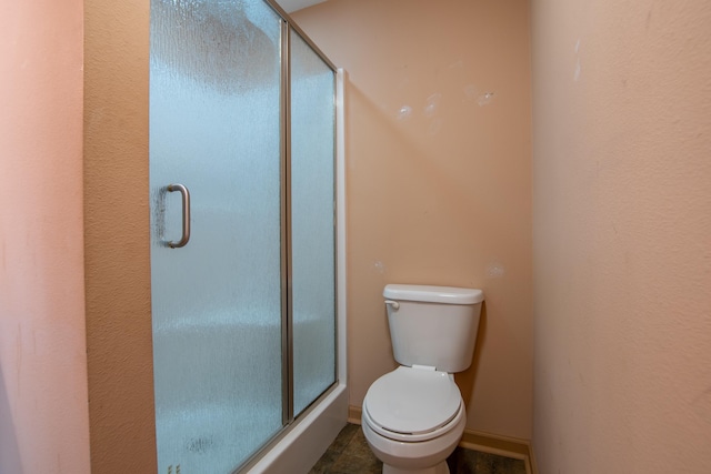 bathroom with toilet and an enclosed shower