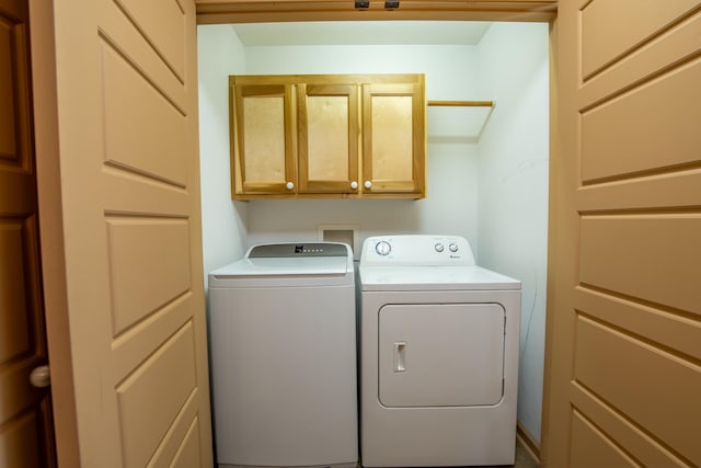 laundry room featuring independent washer and dryer and cabinets