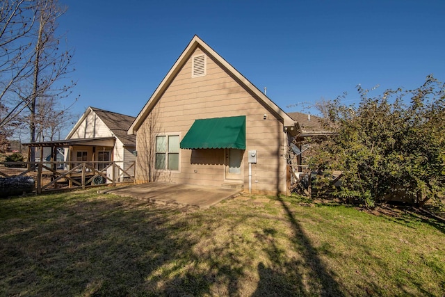 rear view of house with a patio area and a lawn