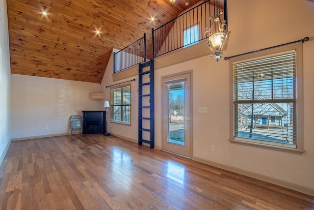 unfurnished living room featuring wood-type flooring, wood ceiling, and high vaulted ceiling