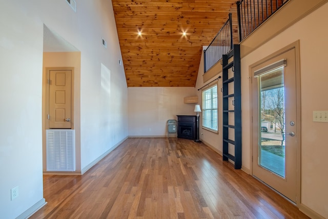 unfurnished living room with a towering ceiling and light hardwood / wood-style floors