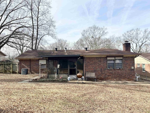 496 Chalmers Rd, Memphis, TN 38120 - back of house with fence, a chimney, brick siding, a sunroom, and central air condition unit