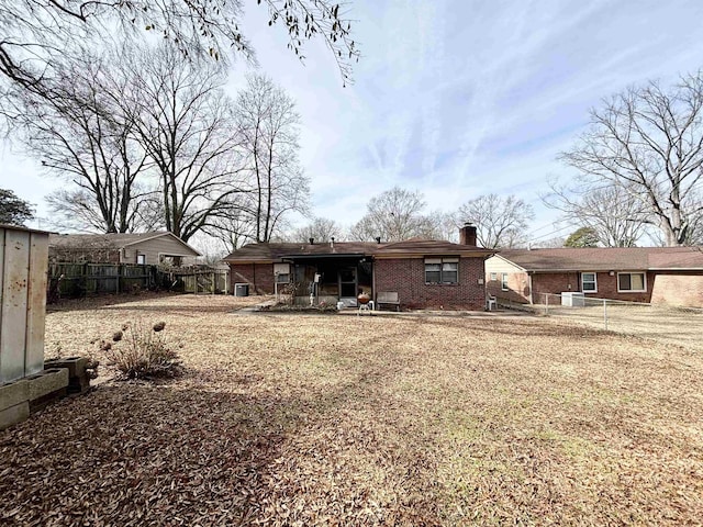 496 Chalmers Rd, Memphis, TN 38120 - rear view of property featuring brick siding, fence, a chimney, and a patio