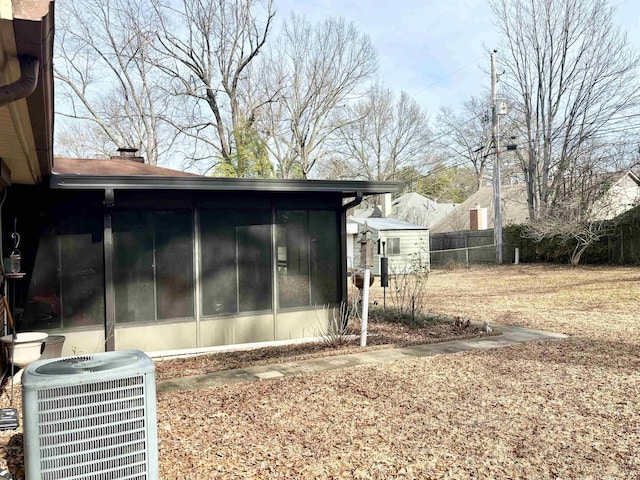 496 Chalmers Rd, Memphis, TN 38120 - view of home's exterior with central air condition unit, fence, a chimney, and a sunroom