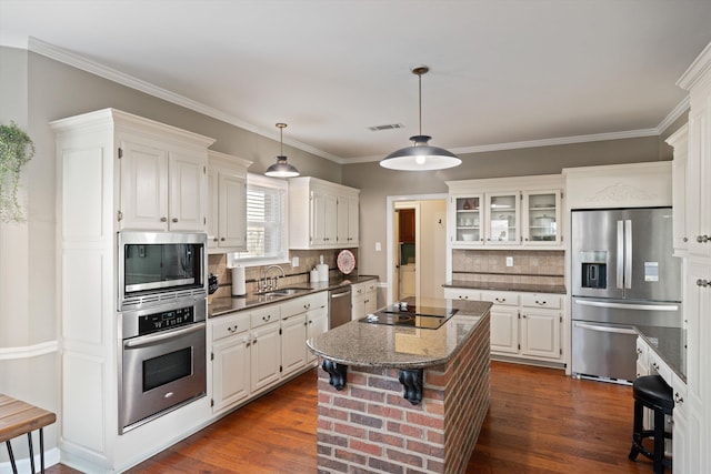 kitchen featuring stainless steel appliances, white cabinets, and a kitchen bar