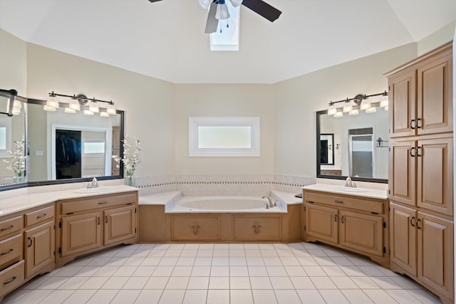 bathroom with ceiling fan, tile patterned floors, vanity, and a washtub