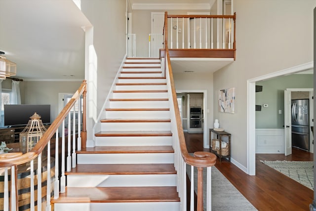 stairway featuring crown molding and wood-type flooring