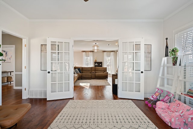 interior space with dark hardwood / wood-style floors, ornamental molding, french doors, and a healthy amount of sunlight