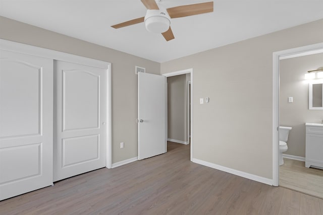 unfurnished bedroom featuring a closet, ceiling fan, ensuite bath, and light hardwood / wood-style flooring