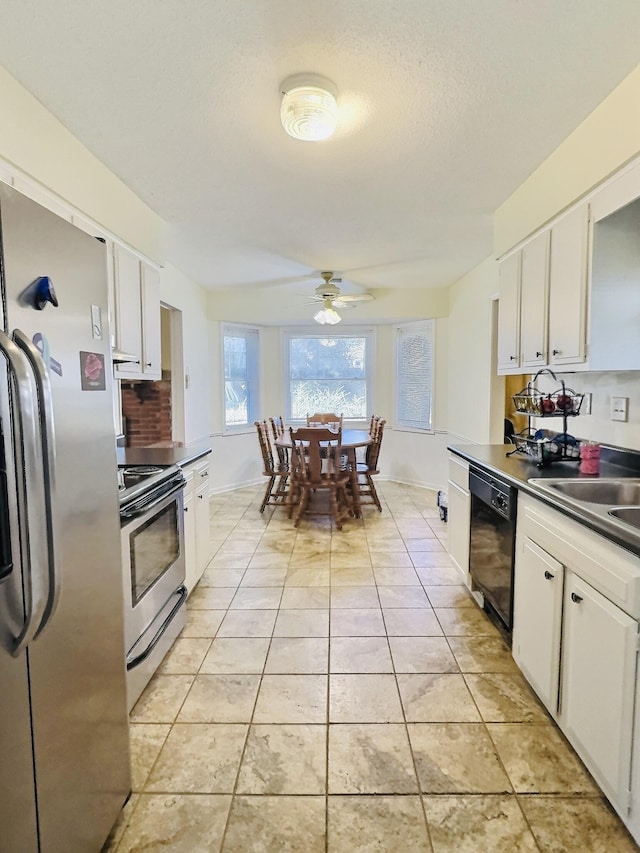 kitchen with sink, white cabinetry, light tile patterned floors, appliances with stainless steel finishes, and ceiling fan